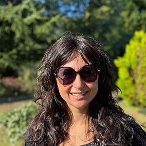 Carolina, mujer de mediana edad sonriendo con cabello largo oscuro y gafas de sol