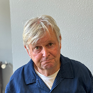 Erwin, hombre adulto con pelo blanco corto y mirada amable en un fondo neutro