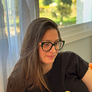 Gloria, mujer adulta con cabello oscuro hasta los hombros, gafas y leve sonrisa