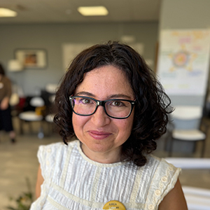Loreto, mujer adulta con cabello castaño oscuro, gafas de ver y una sonrisa ligera
