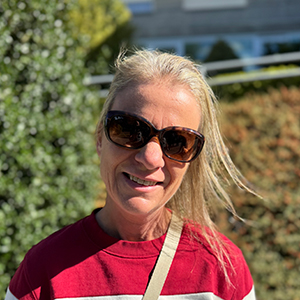 Mónica, mujer joven adulta con cabello rubio claro largo, gafas de sol oscuras y sonrisa cálida