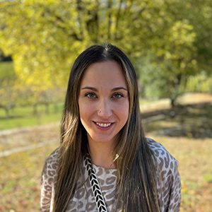 Nuria, mujer joven, con cabello castaño oscuro, expresión cálida y postura profesional