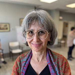 Pilar, mujer adulta con cabello gris corto por encima de los hombros y expresión sonriente