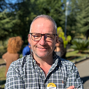 Ramiro, hombre adulto con pelo corto gris y con una leve sonrisa amable